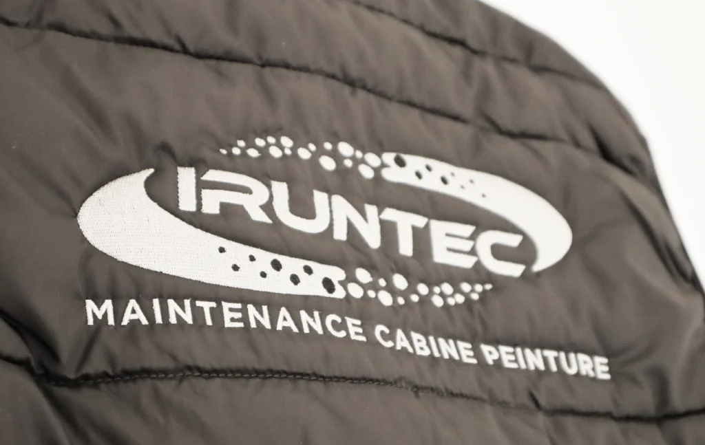 Zoom sur une broderie du logo d'Iruntec sur un bodywarmer. Projet réalisé par Grafixès